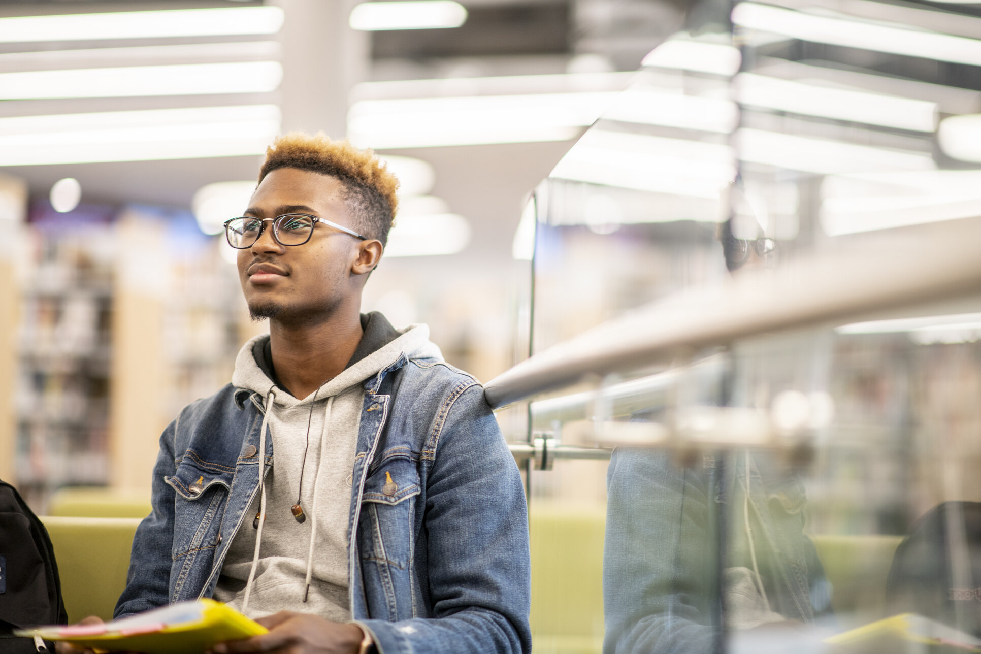 Male student sitting down in a library