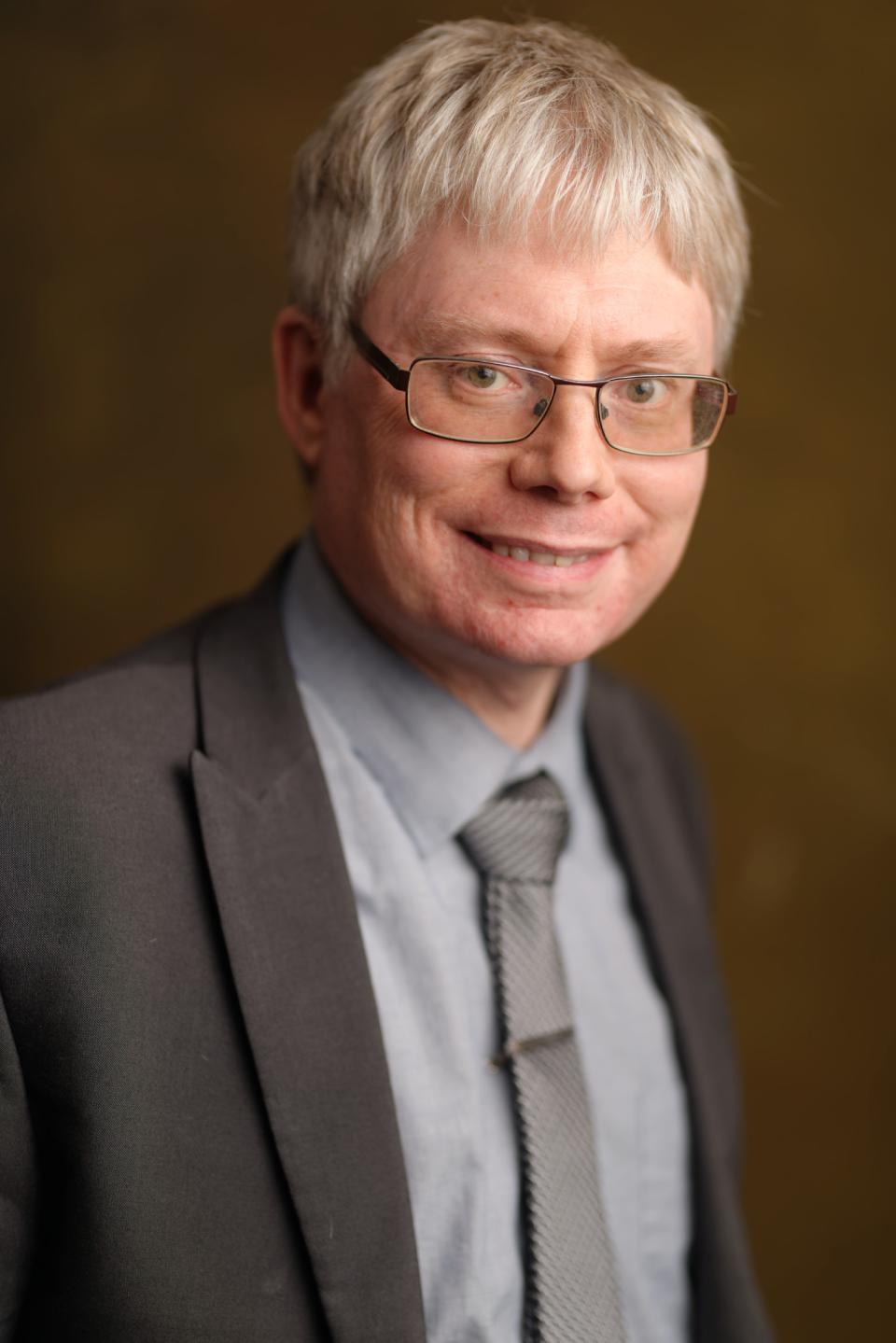 Photograph of Ben Arnold wearing a grey suit