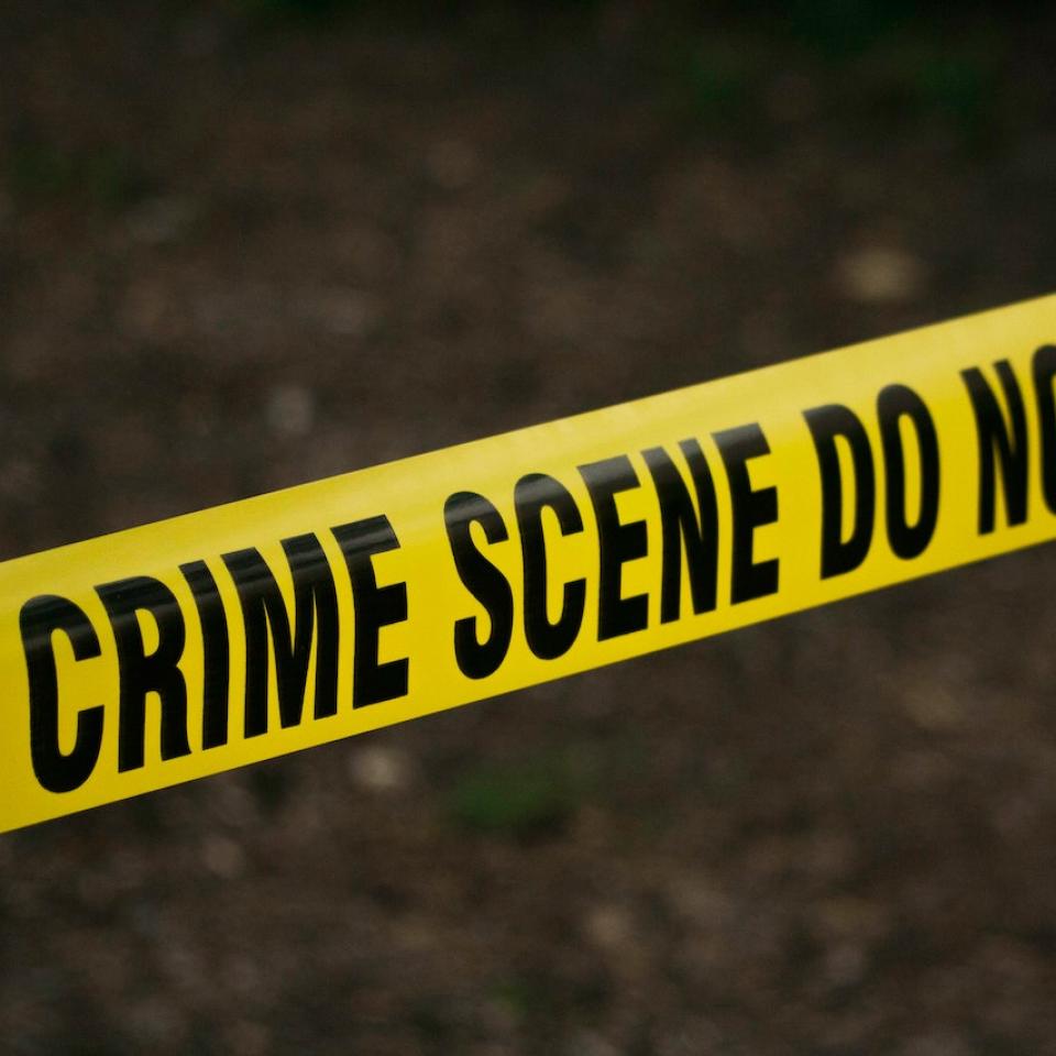 Yellow police tape saying 'crime scene do not cross'