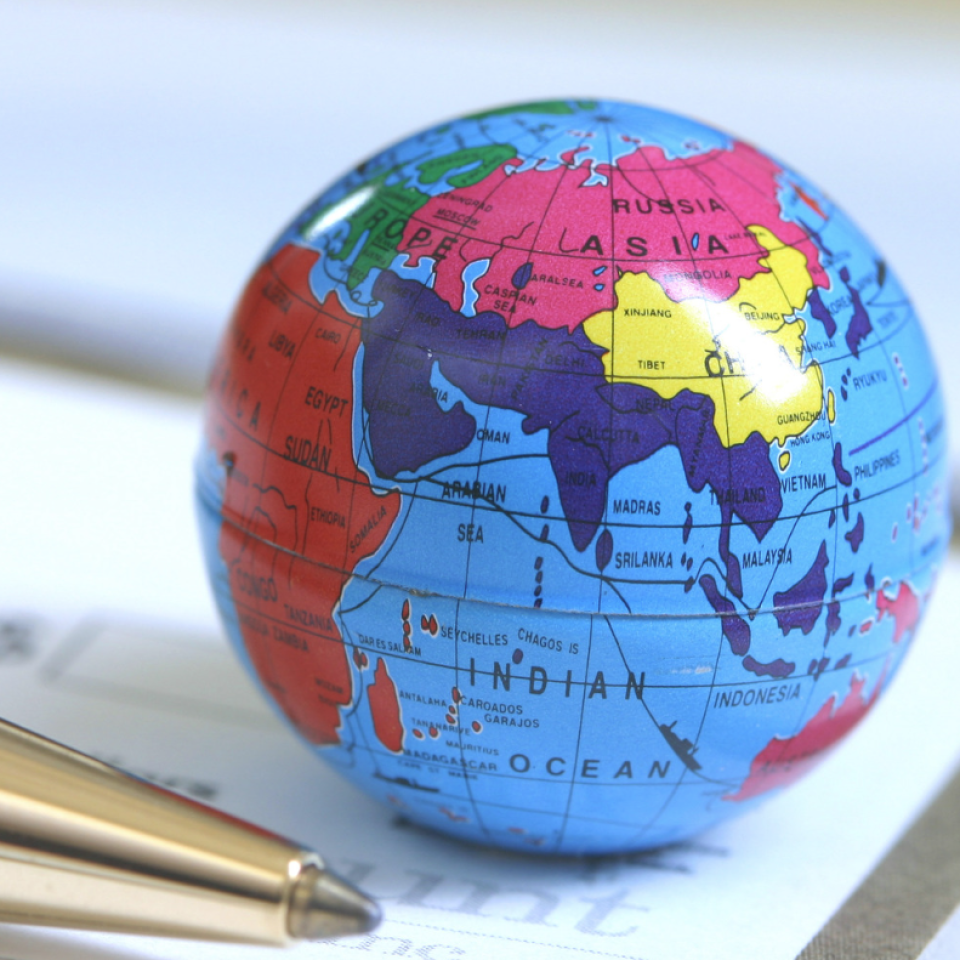 Small globe next to a pen