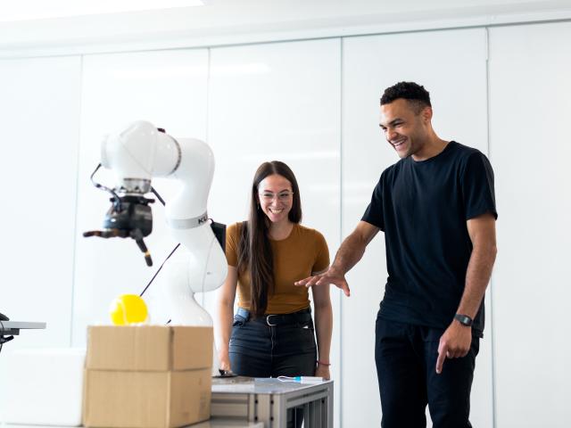 1 male and 1 female engineer working with medical robotic equipment