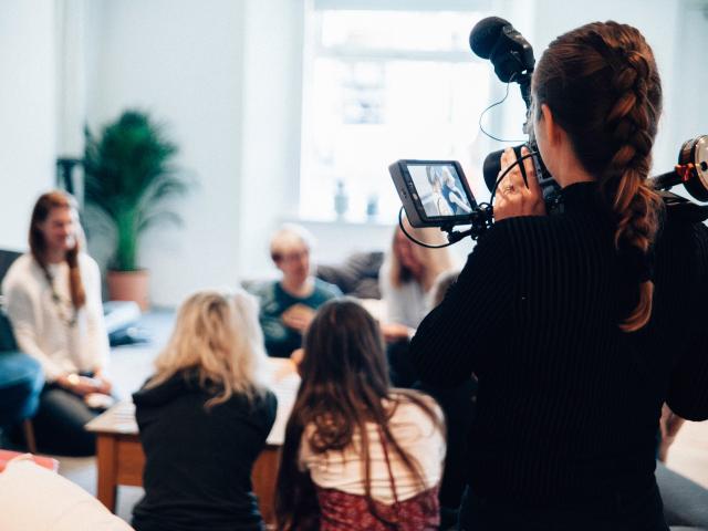 A woman filming a group of other women
