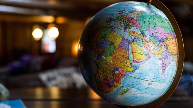 A globe sitting on a desk in a dimly lit room