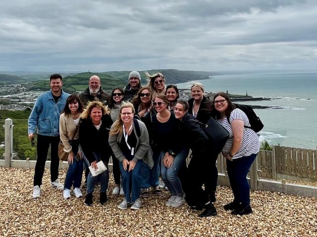 A group of people with the Welsh coast in the background