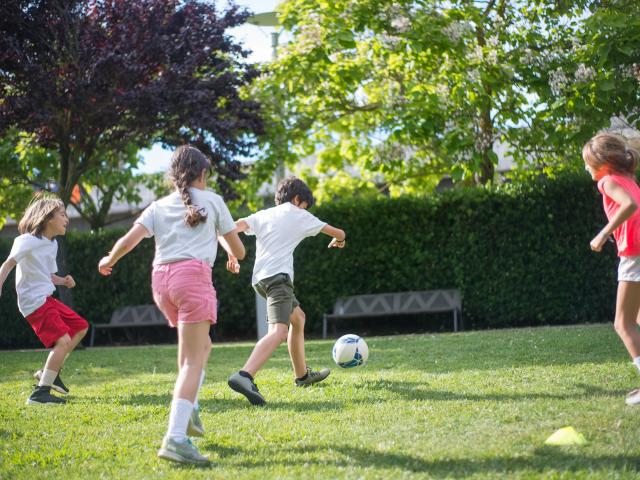 A group of children playing football outdoors
