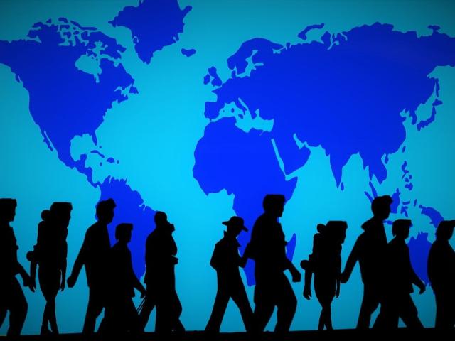 A group of people silhouetted against a blue map of the world
