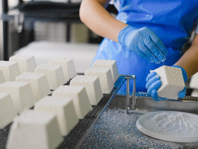 A close up shot of someone making cheeses