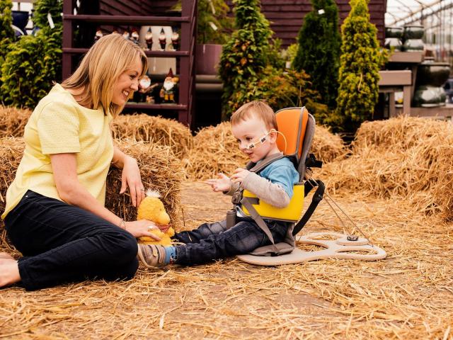 A young boy using the goto seat pictured with a woman