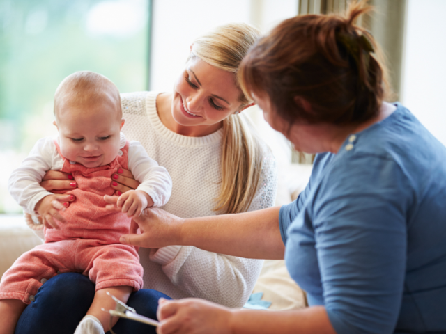 A female health visitor with a mother and her baby