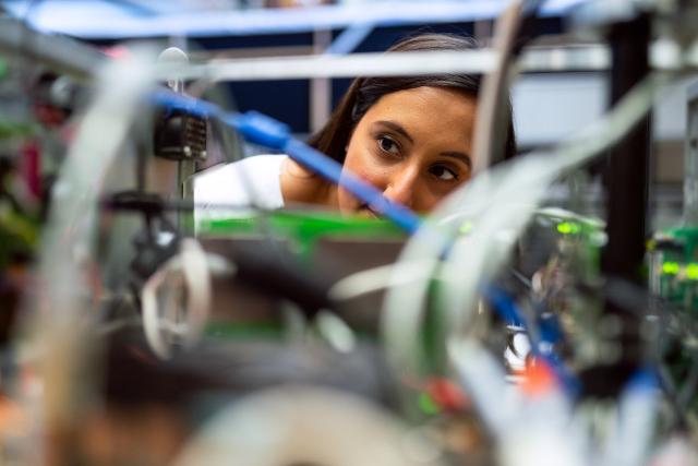 Female engineer looking through wires