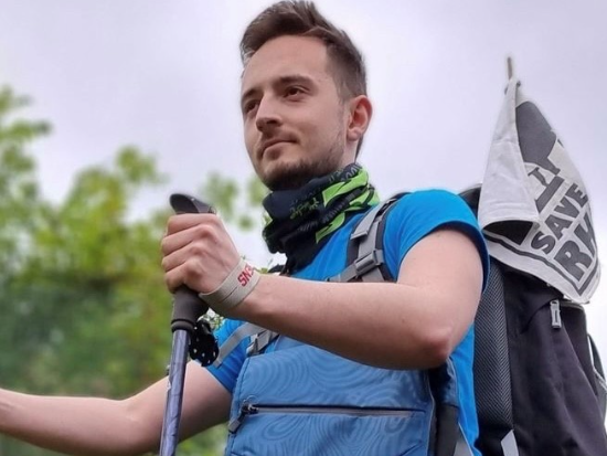 A photo of Ryan Eddowes hiking with walking poles