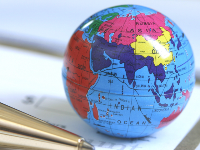 Small globe next to a pen